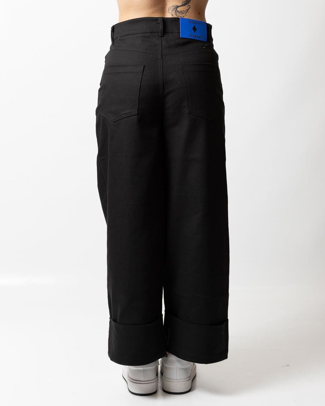 Pantalone Marcelo Burlon svasato con risvolto logato donna