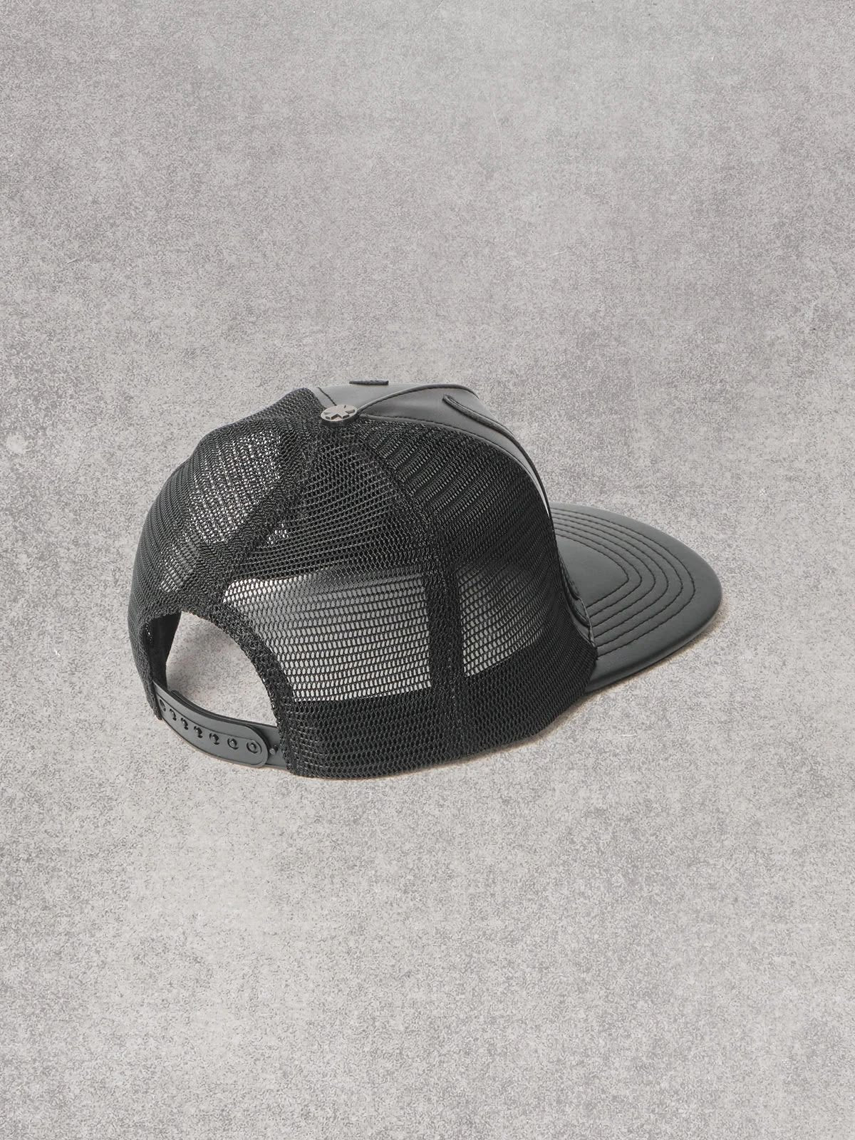 Cappello Comme des Fuckdown in pelle con decorazioni e logo in rilievo