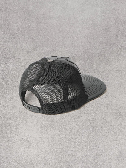 Cappello Comme des Fuckdown in pelle con decorazioni e logo in rilievo